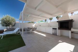 a patio with a table and chairs and a television at Casa Maspalomas private pool, Bbq and private parking in Maspalomas