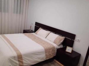 1 dormitorio con 1 cama con sábanas y almohadas blancas en San José Apartamentos Turísticos Miky, en Albacete