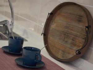 dos tazas de café y un tazón de madera en un mostrador en San José Apartamentos Turísticos Miky, en Albacete