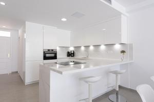 a white kitchen with a sink and a stove at BLUE SEA II - FRONT BEACH in Puerto de Mogán