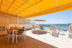 a dining room with a table and chairs and the ocean at BLUE SEA I in Puerto de Mogán