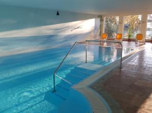 a swimming pool with stairs in a building at Vineta Strandhotels in Zinnowitz