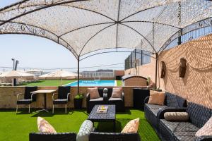 a patio with chairs and a table and an umbrella at Casa Adara - Heated pool included in San Bartolomé