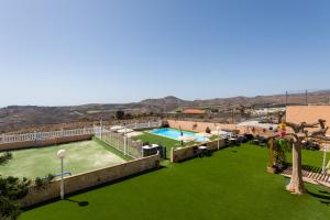 a resort with a swimming pool and a green lawn at Casa Adara - Heated pool included in San Bartolomé