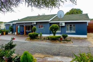 a blue house with a satellite on the roof at Motseleng Guest House in Palatswe