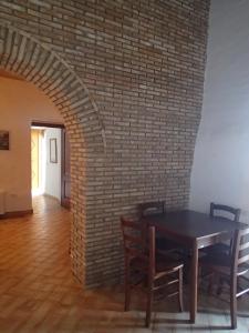 a dining room with a table and a brick wall at Patitiri in Santa Teresa di Riva