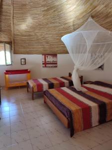 Habitación con 3 camas y techo. en safari village case 29, en Saly Portudal