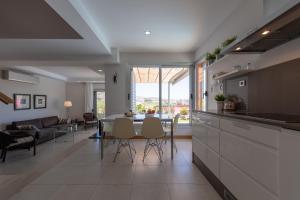 cocina y sala de estar con mesa y sillas en VILLA SALOBRE en Salobre