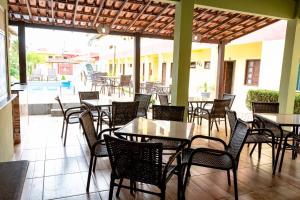 a restaurant with tables and chairs on a patio at Condomínio Golden Goes in Porto Seguro