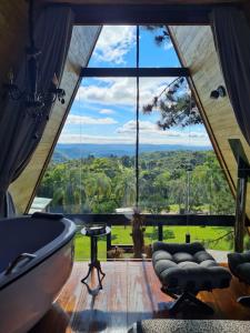 a large room with a large window in a house at Estalagem La Hacienda in Gramado