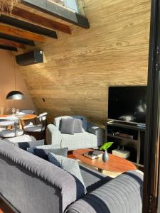un salon avec des canapés et une télévision à écran plat dans l'établissement Estalagem La Hacienda, à Gramado