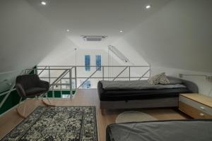 um quarto com uma cama e uma cadeira em Holzhaus Sikonda em Komló