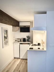 Una cocina con gabinetes blancos y un horno de estufa. en Le Cocon Petite France, en Estrasburgo 11 fotos más