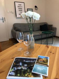 una mesa con dos copas de vino y un libro sobre ella en Bankowa 8 Guest Rooms, en Zielona Góra