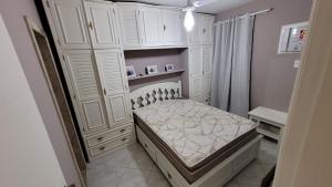 ein kleines Schlafzimmer mit einem Bett und weißen Schränken in der Unterkunft Apartamento CABO FRIO - PRAIA DO FORTE in Cabo Frio