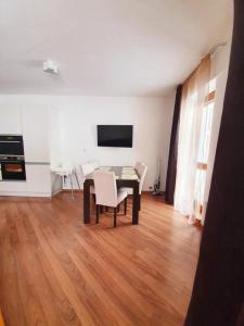 ein Wohnzimmer mit einem Tisch, Stühlen und einem TV in der Unterkunft Apartmán 27, Kamzík in Donovaly
