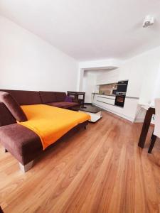 ein Wohnzimmer mit einem Sofa und einer gelben Decke in der Unterkunft Apartmán 27, Kamzík in Donovaly