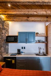 uma cozinha com armários azuis e um lavatório em Villa Mosaico - Luxury Lofts em Real de Catorce