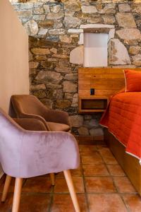 a bedroom with a bed and a stone wall at Villa Mosaico - Luxury Lofts in Real de Catorce