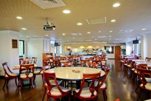 uma sala de jantar com mesas e cadeiras de madeira em F Hotel Tainan em Tainan