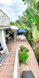 een patio met een tafel en een blauwe parasol bij 4145 By The Sea Inn & Suites in Fort Lauderdale