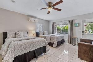 a bedroom with two beds and a ceiling fan at 4145 By The Sea Inn & Suites in Fort Lauderdale