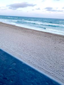 a surfboard on a beach with the ocean at 4145 By The Sea Inn & Suites in Fort Lauderdale