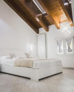 Residenze Niguarda في ميلانو: غرفة نوم بيضاء مع سرير في غرفة ذات سقوف خشبية