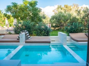 una piscina con 2 camas junto a un complejo en Castelli Hotel-Adults Only, en Laganas