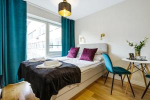 a bedroom with a bed with purple pillows and a window at Bob W Tallinn City Centre - Avangard in Tallinn