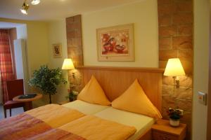 Un dormitorio con una cama con almohadas amarillas. en Birnbaumhof - Hotel Pension und Ferienwohnungen, en Schwedelbach