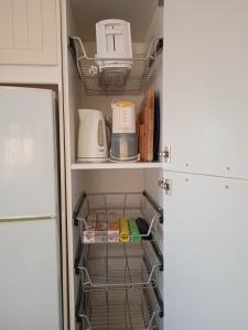 a refrigerator filled with dishes and appliances at Calma in Perdika