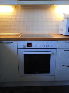 a kitchen with a white oven with a clock on it at Calma in Perdika