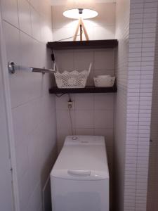 a small bathroom with a toilet and a light at Calma in Perdika