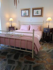 a bedroom with a large bed with pink pillows at Calma in Perdika
