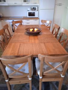 a wooden table with a bowl of fruit on it at Calma in Perdika
