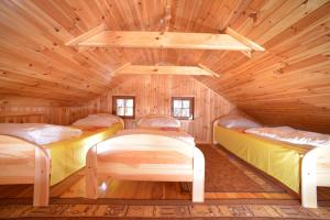 a room with three beds in a wooden cabin at Domki Pod Wydmami 40m od plaży in Dźwirzyno