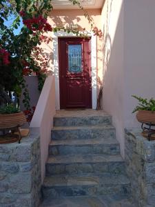 a red door with stairs in front of a house at Calma in Perdika