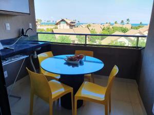 - une table avec des chaises et une corbeille de fruits sur le balcon dans l'établissement Condominio Nui Supreme - By Maya - Muro Alto - Porto de Galinhas, à Porto de Galinhas
