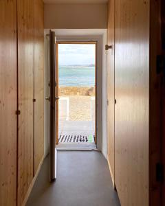 a door to a room with a view of the ocean at Baleal waterfront in Baleal