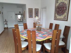 a dining room table and chairs with a colorful table cloth at Apartamento da Maria Eunice in Poços de Caldas