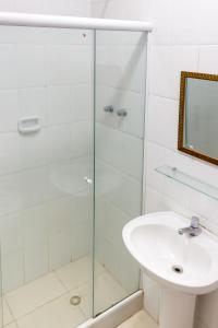 a bathroom with a sink, mirror, and bath tub at Hotel Carioca in Rio de Janeiro