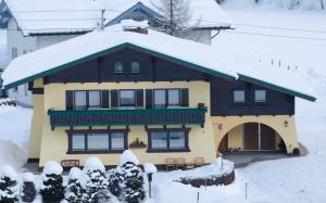 a large house with snow on the roof at Ferienwohnungen Passrugger in Eben im Pongau