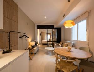a kitchen and living room with a table and a dining room at CALM SUITES Molino Corteza del Carmen in Granada