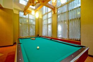 a pool table in a room with windows at F Hotel Tainan in Tainan