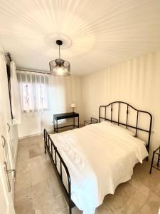 een slaapkamer met een groot wit bed en een kroonluchter bij La Arenita - oceanview apartment in Palm-mar +26 foto's