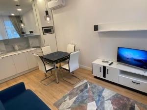 ein kleines Wohnzimmer mit einem Tisch und einem TV in der Unterkunft Moder Chic Apartment in Center-PRIME RENTALS in Kaunas