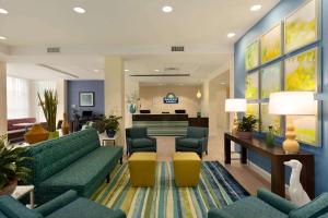 a lobby with green couches and a waiting room at Days Inn & Suites by Wyndham Altoona in Altoona