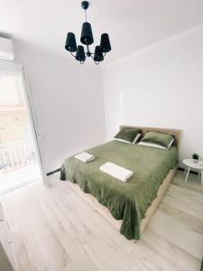 ein Schlafzimmer mit einem Bett mit einer grünen Bettdecke in der Unterkunft Diamond apartment in Thessaloniki