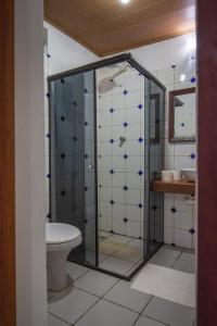 y baño con ducha de cristal y aseo. en Apartamentos Quintal - 2 Quartos Suítes e Sala, en Morro de São Paulo